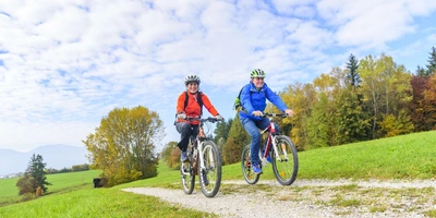 Zwei Personen fahren in der Natur Fahrrad.
