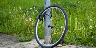 Ein Fahrradreifen ist an einer Laterne mit einer Fahrradkette angeschlossen.