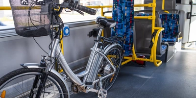 Ein Elektrofahrrad steht in einem öffentlichen Bus neben leeren Sitzplätzen.