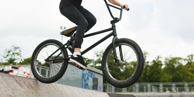 BMX-Fahrerin springt mit einem BMX über eine Rampe