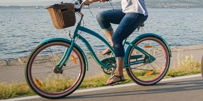 Frau fährt auf einem Cruiser am Ufer