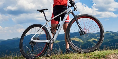 Mann mit einem Crossbike steht auf einem Berg