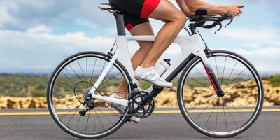 Mann fährt in Sportklamotten auf einem Triathlonrad