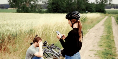 Der Fahrrad Pannendienst ist für dich da Mann sitzt bei einer Fahrradpanne verzweifelt auf dem Boden und wartet auf den Pannendienst