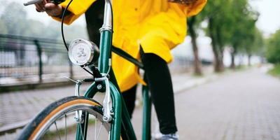 Fahrrad Regenjacke - der beste Regenschutz? Person fährt mit einer Regenjacke Fahrrad