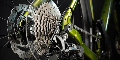 Fahrrad Schaltung Typen: Überblick & Vergleich Detailansicht eines Fahrradschaltwerks mit grünem Rahmen und Bremsen.