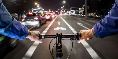 Radfahrer bei Dunkelheit im Stadtverkehr auf Fahrradweg
