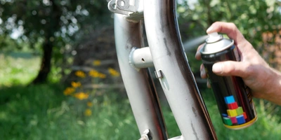 Fahrradrahmen wird mit einer Sprühdose lackiert