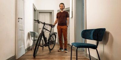 Mann steht im Flur neben einem Fahrrad - Bike statt Auto