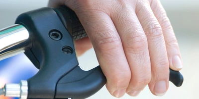 Hand greift eine Fahrradbremse