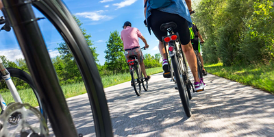 Fünf Personen machen eine Fahrradtour bei gutem Sommerwetter. 