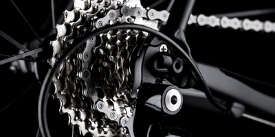 Nahaufnahme eines Fahrradkettenantriebs auf schwarzem Hintergrund.