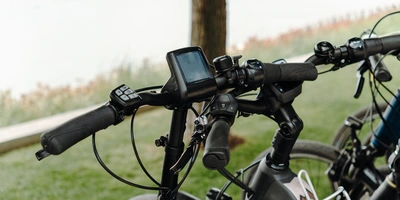 Alles zum Fahrradnavi-Test Lenker von Fahrrädern im Freien mit einem Bildschirm und grüner Umgebung.
