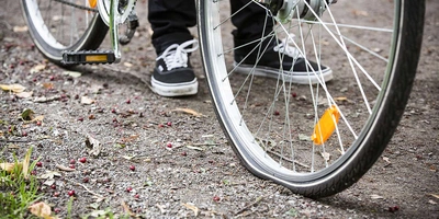 Mensch geht mit seinem Fahrrad spazieren.