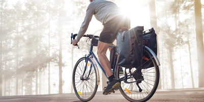 Fahrradfahrer fährt mit seiner Fahrradtasche im Wald
