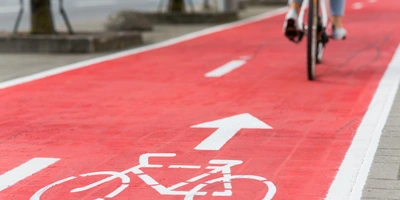 Bike Sicherheit Radweg auf rotem Belag mit weißem Fahrradsymbol und Richtungspfeil