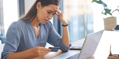 Frau verzweifelt vor Laptop wegen eines Fake-Shops