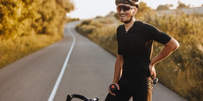 Mann sitzt lächelnd auf Rennrad