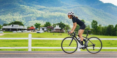 Frau fährt mit Rennrad auf Straße