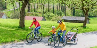 Eine Familie fährt ihre E-Bikes