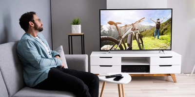 Ein Mann der gerade Fernseh schaut der gerade ein Fahrrad zeigt