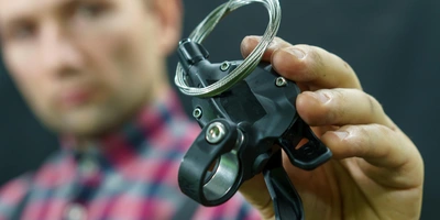 Mann hält Teil einer Fahrradschaltung in der Hand