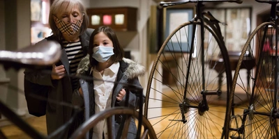 Zwei Personen begutachten alte Fahrräder im Museum