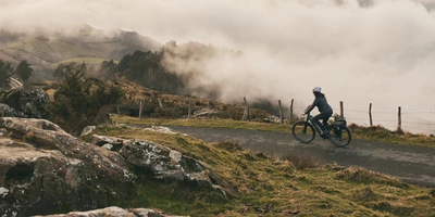 Frau fährt mit einem E-Bike einen Hügel herunter