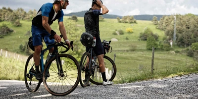 Zwei Männer auf Gravelbike schauen sich die Natur an.