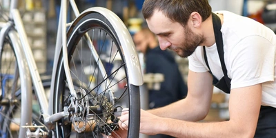 Person pflegt seine Fahrradkette 