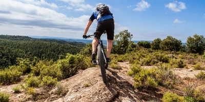 Mountainbiker fährt mit seinem Bike über einen Berggipfel