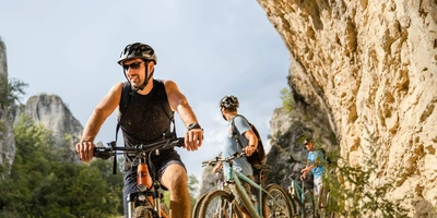Fahrradfahrer mit E-Mountainbikes in den Bergen auf Tour