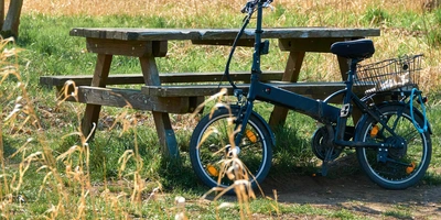 Ein E-Klapprad steht auf einer Wiese