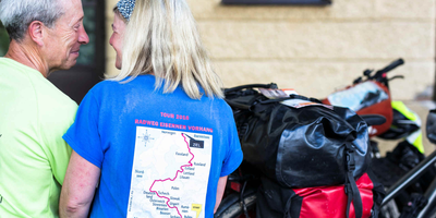 Der Iron Curtain Trail – Gute gerüstet für die Fahrt Zwei Personen sitzen auf einer Bank und lächeln