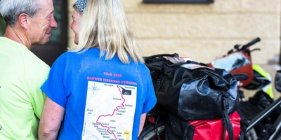 Zwei Personen sitzen auf einer Bank und lächeln