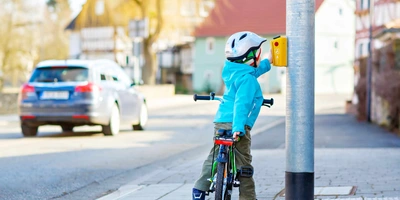 Kind auf Weg zur Schule hält an Ampel