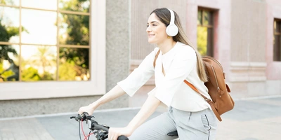 Frau mit Kopfhörern fährt Fahrrad