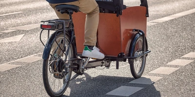 Lastenrad statt Auto? Alle Vorteile aufgelistet Eine Person fährt ein Lastenrad