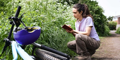 Frau mit umgekippten Fahrrad an einem Feldrand