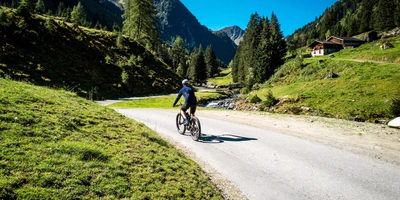 Mit dem Fahrrad über die Alpen - für den perfekten Radweg Ein Fahrradfahrer fährt durch die Berge