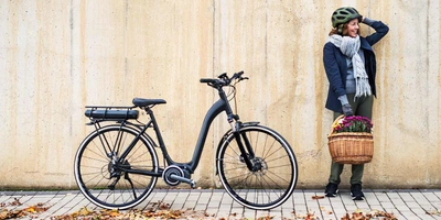 Alle Moustache Lundi Modelle im Vergleich Frau steht neben ihrem E-Bike
