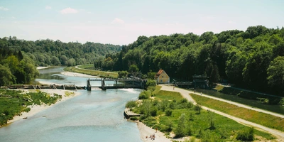 München Radtour - diese Strecke solltest du kennen Aussicht über die Isar von der Großhesseloher Brücke im Sommer in München.