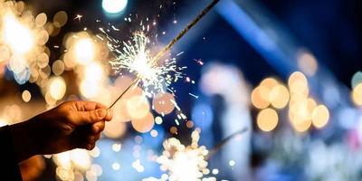 Mann hält abbrennende Wunderkerze in Hand