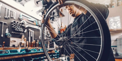 Mann untersucht Fahrrad Reifen.