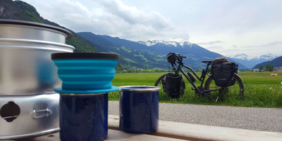 Fahrrad steht mit Reisegepäck auf einer Wiese.