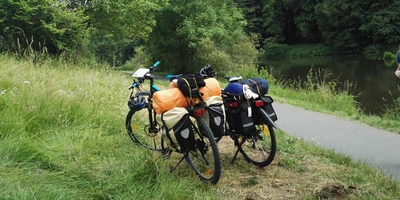 Zwei Fahrräder stehen in der Natur bepackt mit viel Gepäck