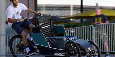 Mann mit Fahrradhelm fährt auf Elektro Lastenrad