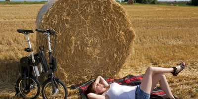 Person mit Faltrad an einem Heuballen