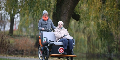 Ältere Person wird in einer Rikscha transportiert