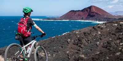 Seniorin unterwegs mit dem Mountainbike auf der Insel Lanzarote auf den Kanarische Inseln 